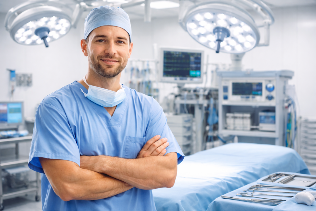 Cirurgião em sala de operações moderna, com equipamentos cirúrgicos e mesa preparada ao fundo.
